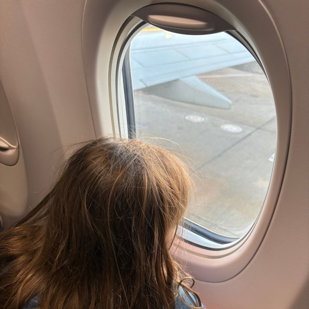 Girl looking out airplane window