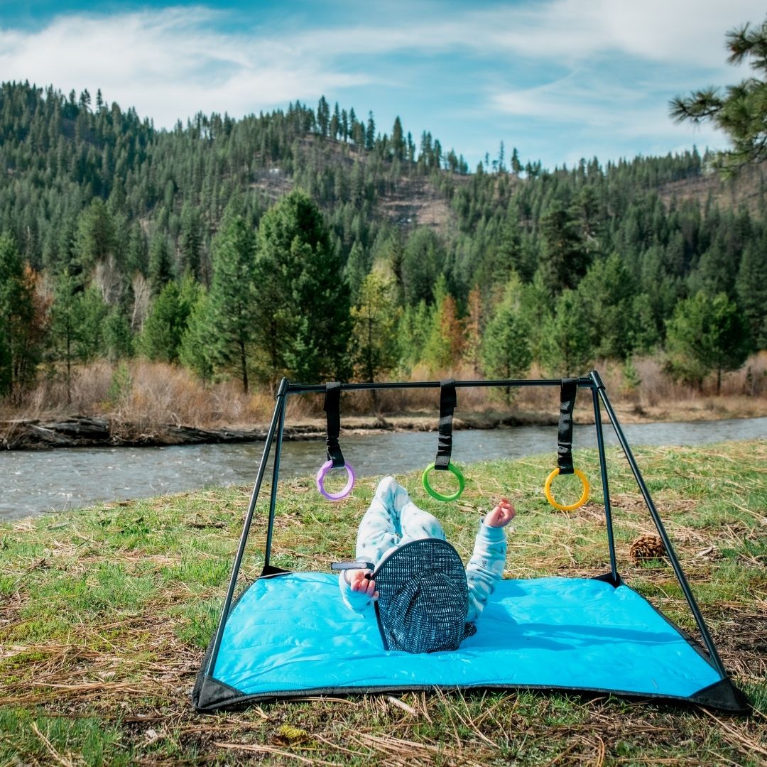 Baby on Lay and Play Adventure Mat in mountains by river